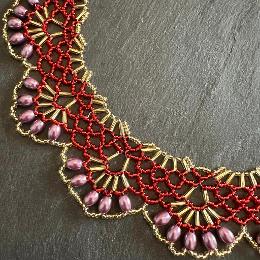 A close up photo of a lace necklace made from seed beads.