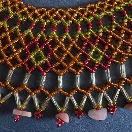 A close up photo of a lace necklace made from brown seed beads.