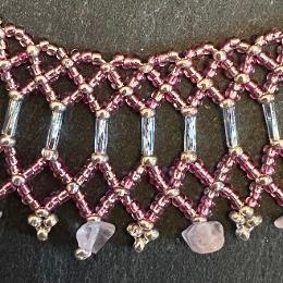 A close up photo of a lace necklace made from brown seed beads.