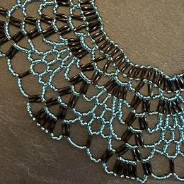 A close up photo of a beaded lace necklace.